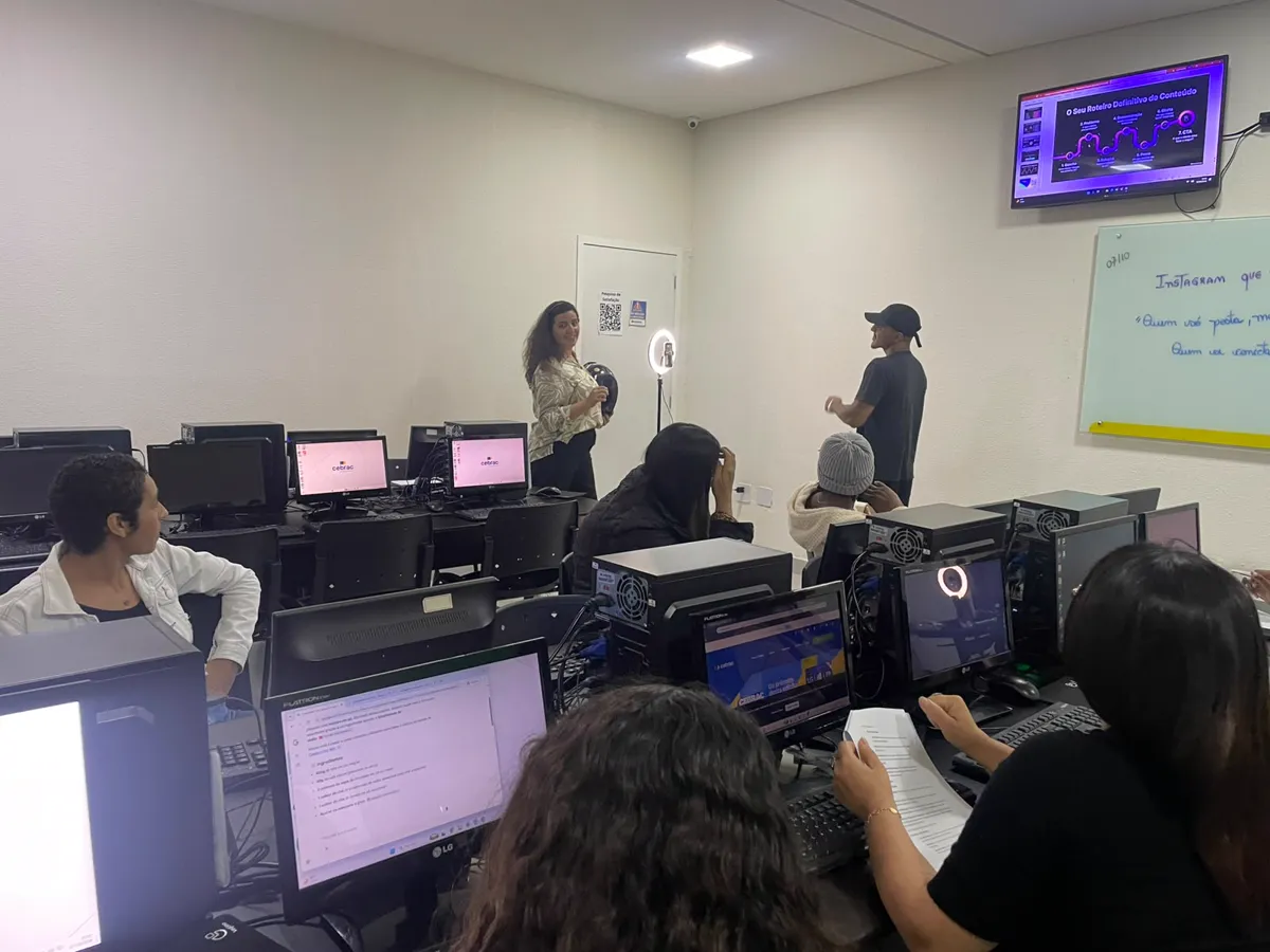 Alunos praticando nos computadores do laboratório