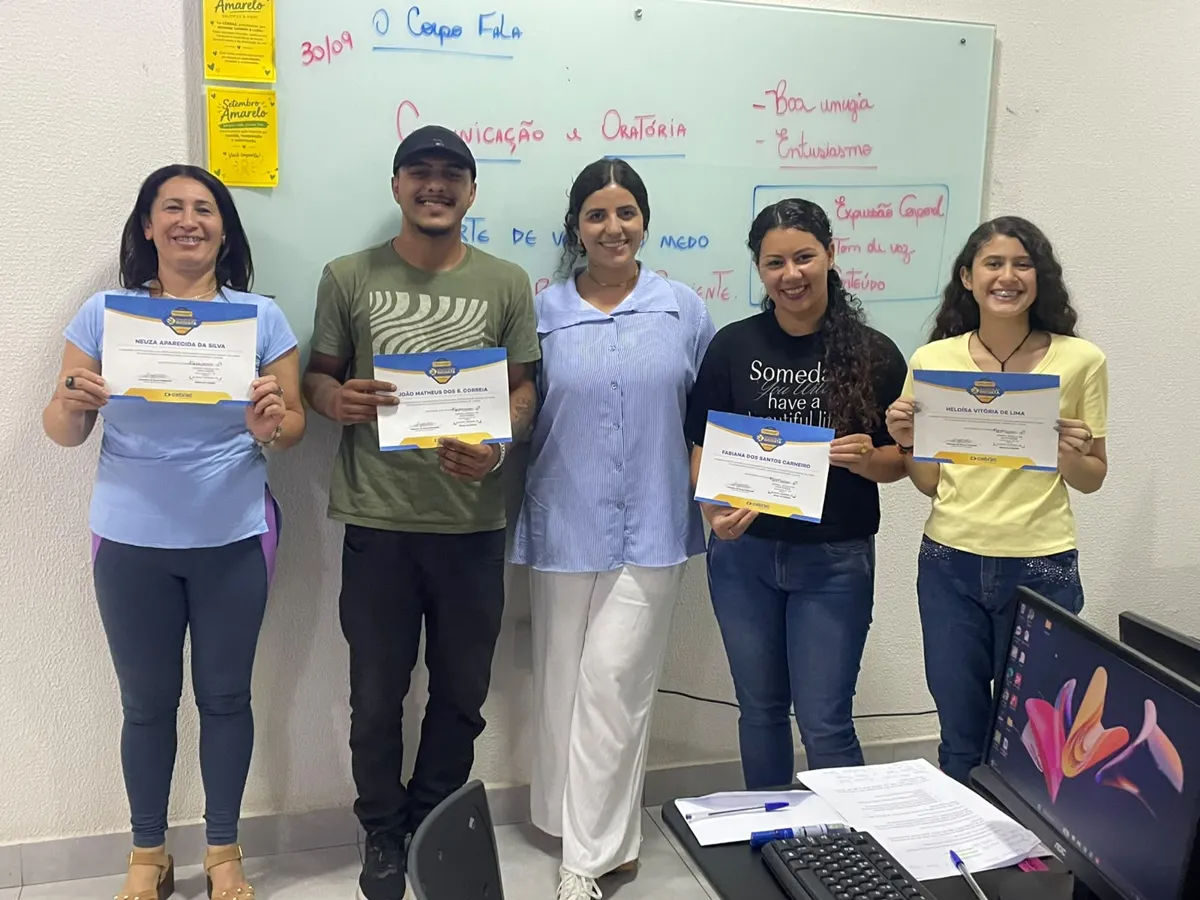 Alunos sorrindo com os certificados na sala de aula